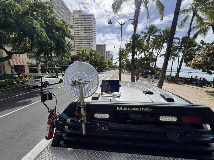 Truck-mounted 60 GHz dish and monitor relaying live course video on Kalākaua Avenue